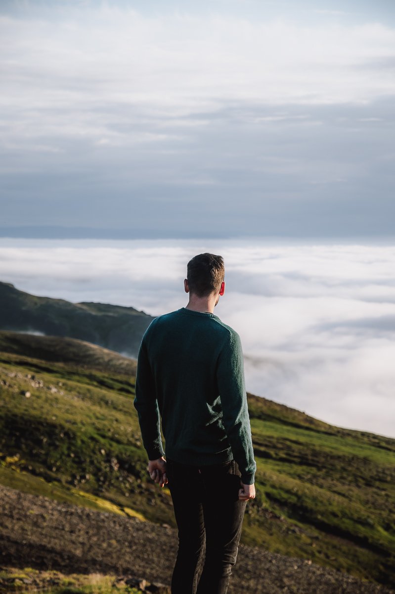 Guy standing looking at a cloud inversion during a Iceland ring road itinerary