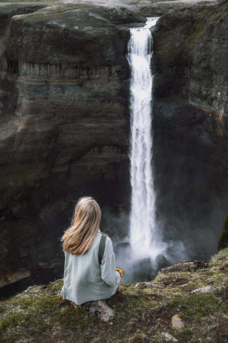 Girl sitting looking out over Iceland Waterfall Haifoss