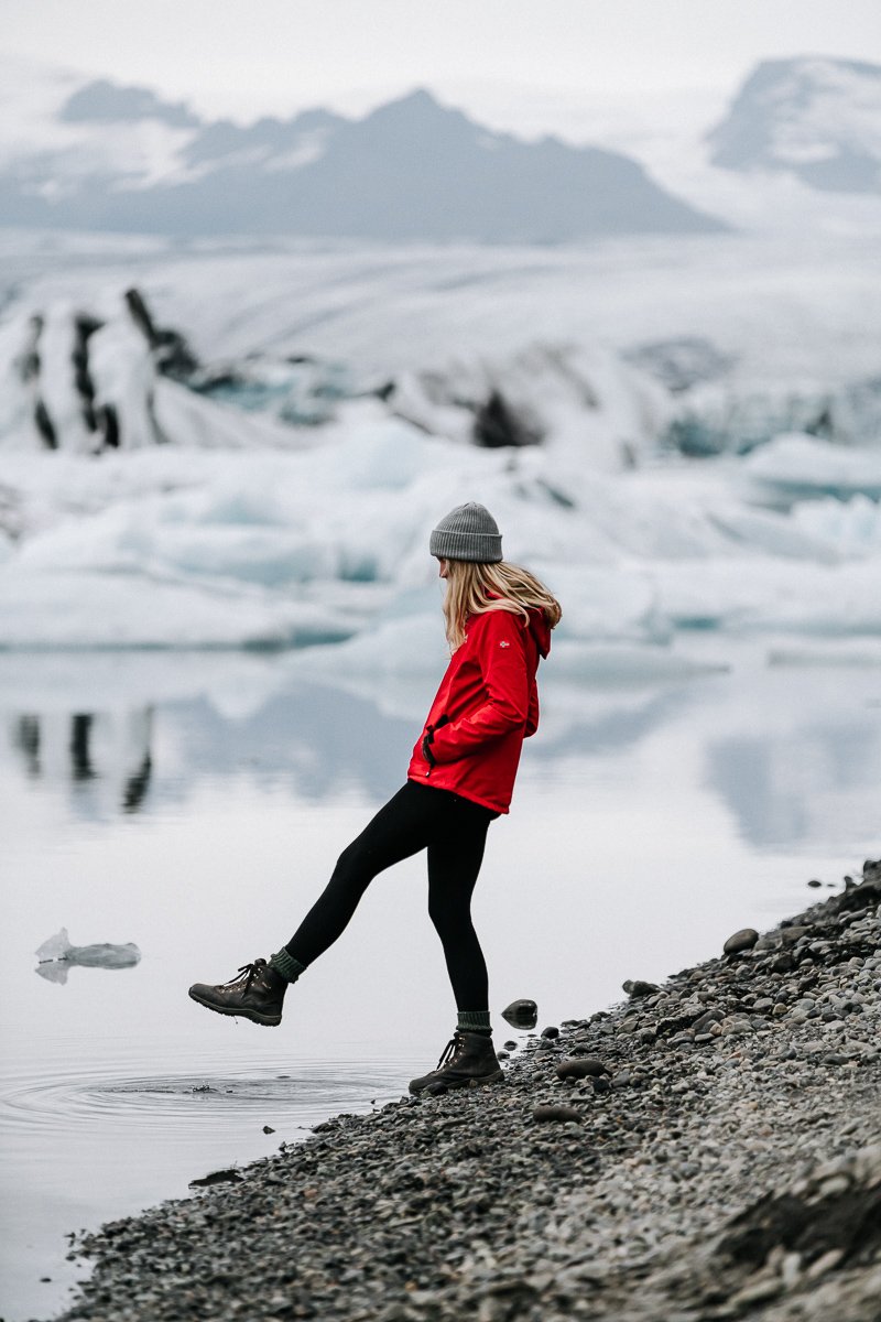 Girl touches foot on the Jökulsárlón Glacier Lagoon just off the Iceland Ring Road Itinerary