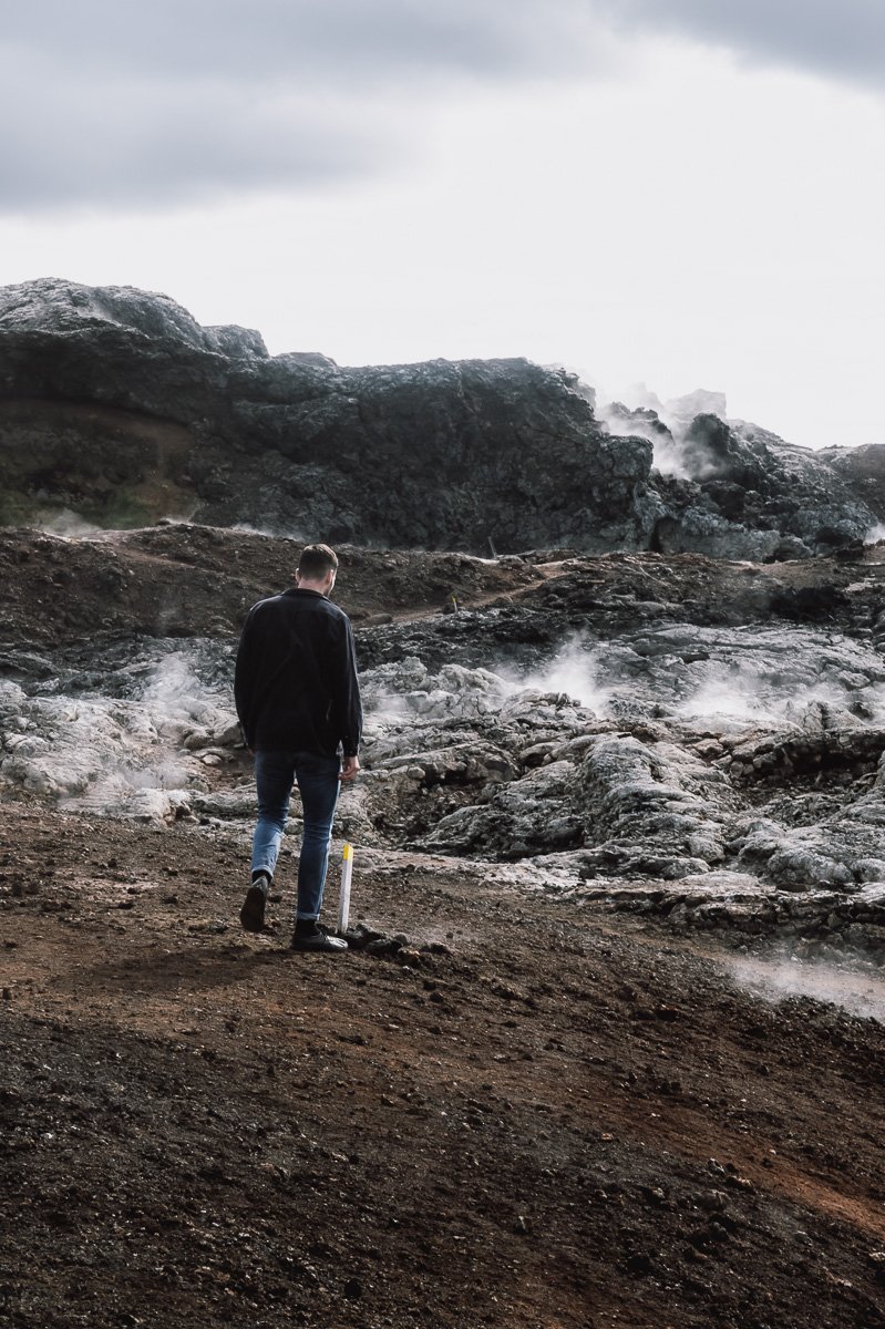 Guy walking amongst the steaming lava fields in Krafla Lava Fields on an Iceland Roadtrip
