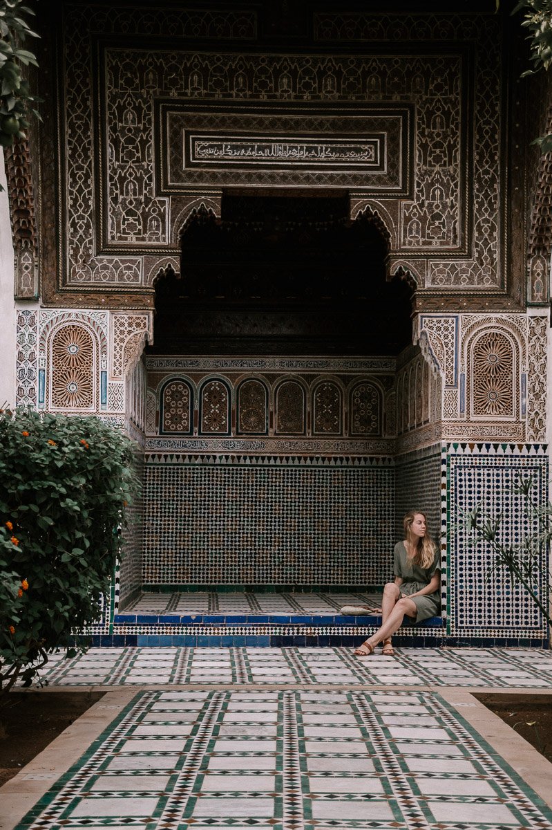 Girl sitting inside the Bahia Palace which is one of the fun things to visit in Marrakech Morocco