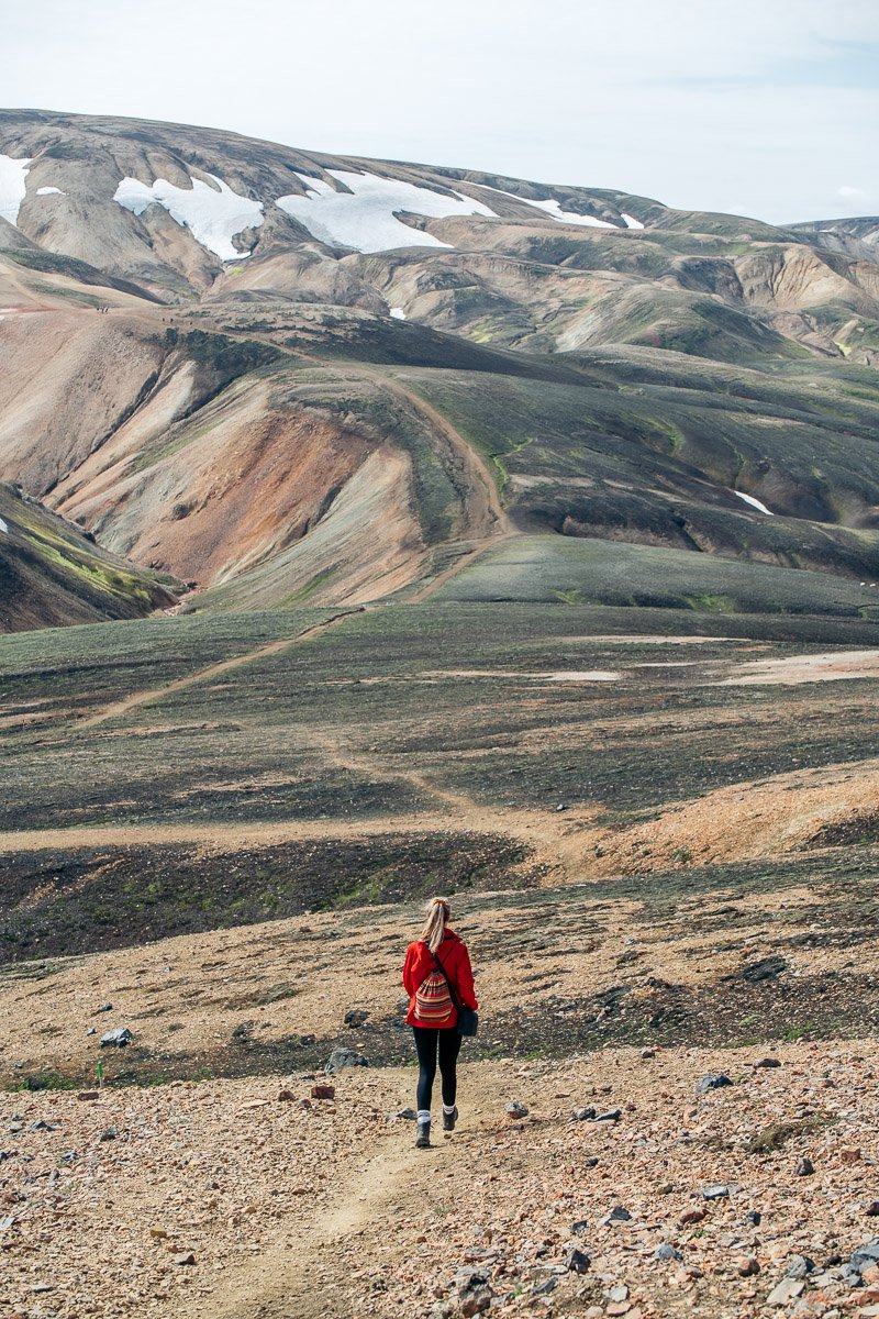 A girl walking towards the colourful mountains of Landmannalaugar