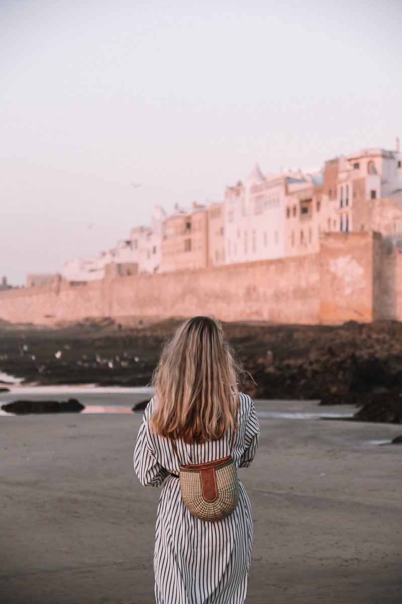 A girl walking towards the Essaouira Medina Walls