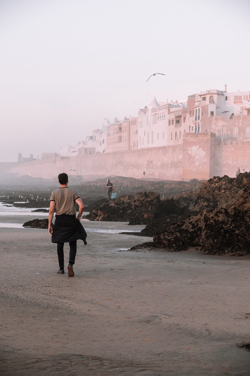 A man walking towards the Essaouira Medina Walls